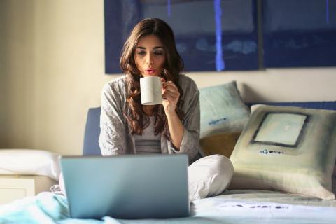 Bm Woman In Grey Jacket Sits On Bed Uses Grey Laptop 935743.jpg