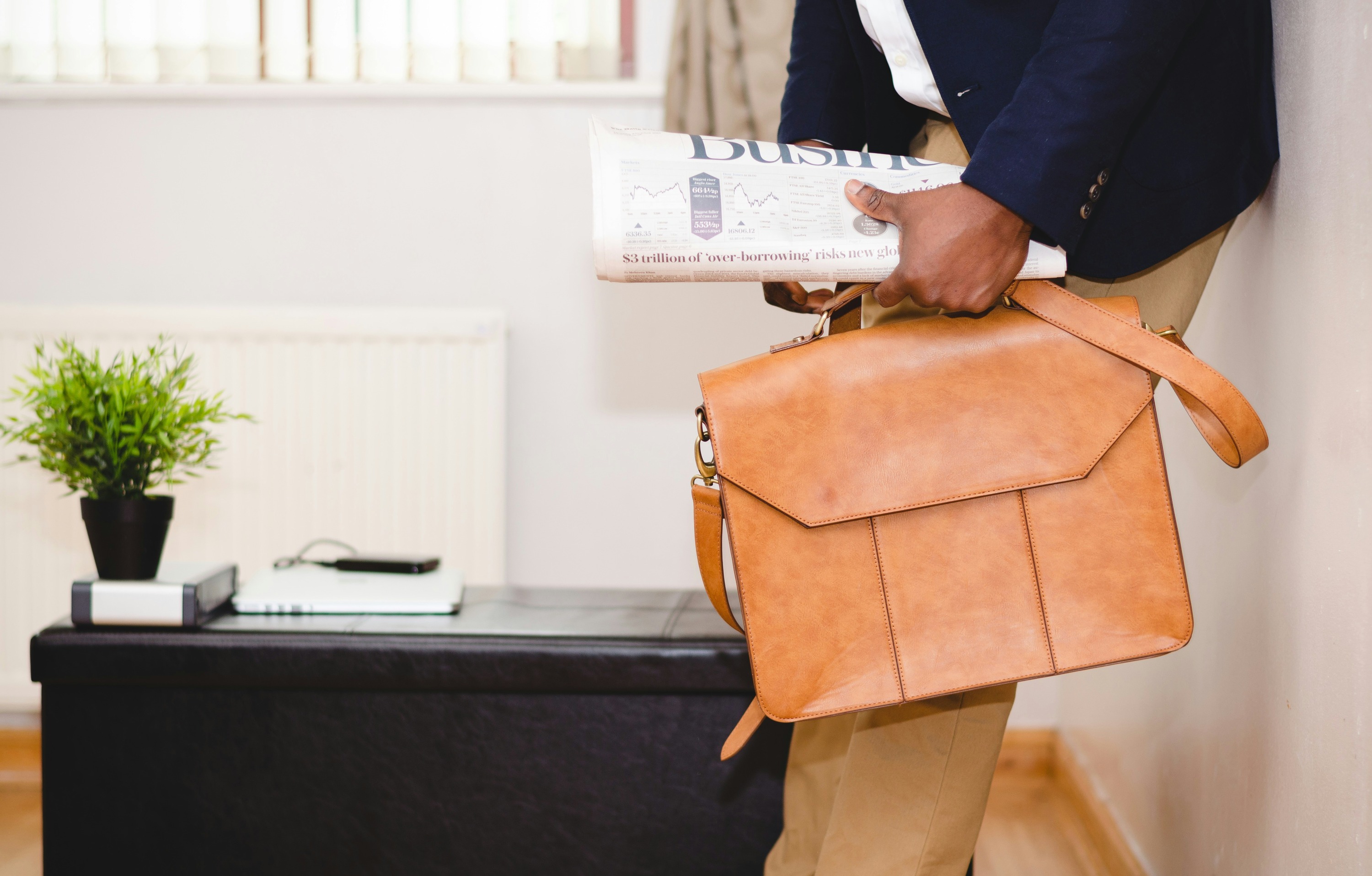 Man walking with folded newspaper and briefcase