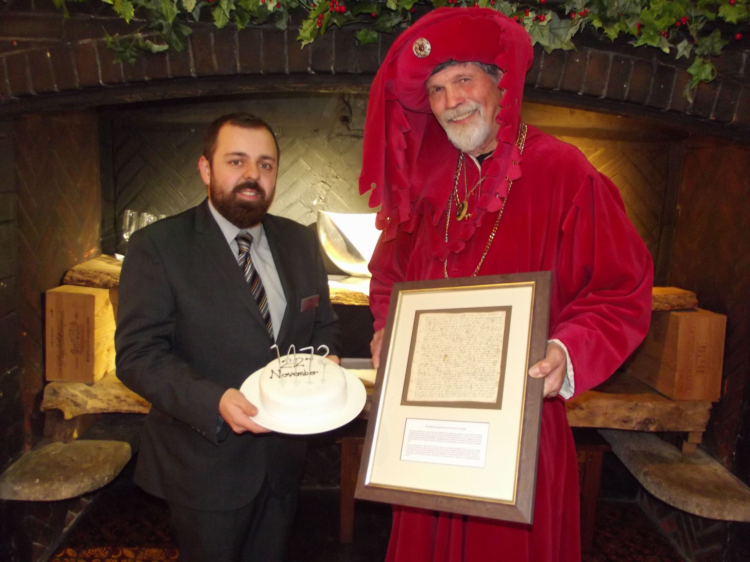 Sam Masters, Food Services Manager and Rob Knee (John Paston) with the birthday cake and the Maids Head Paston letter