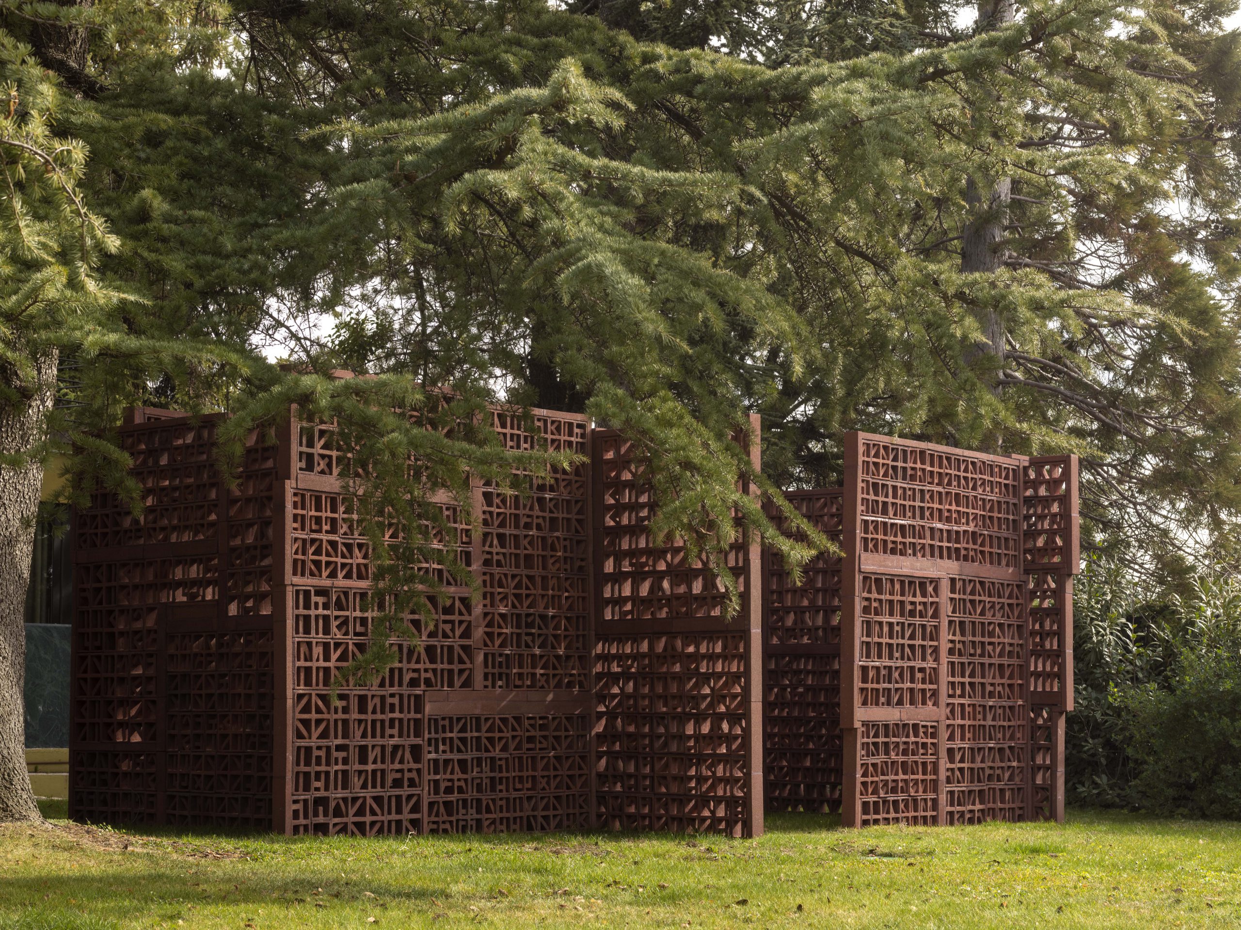 A terracotta screen amongst trees