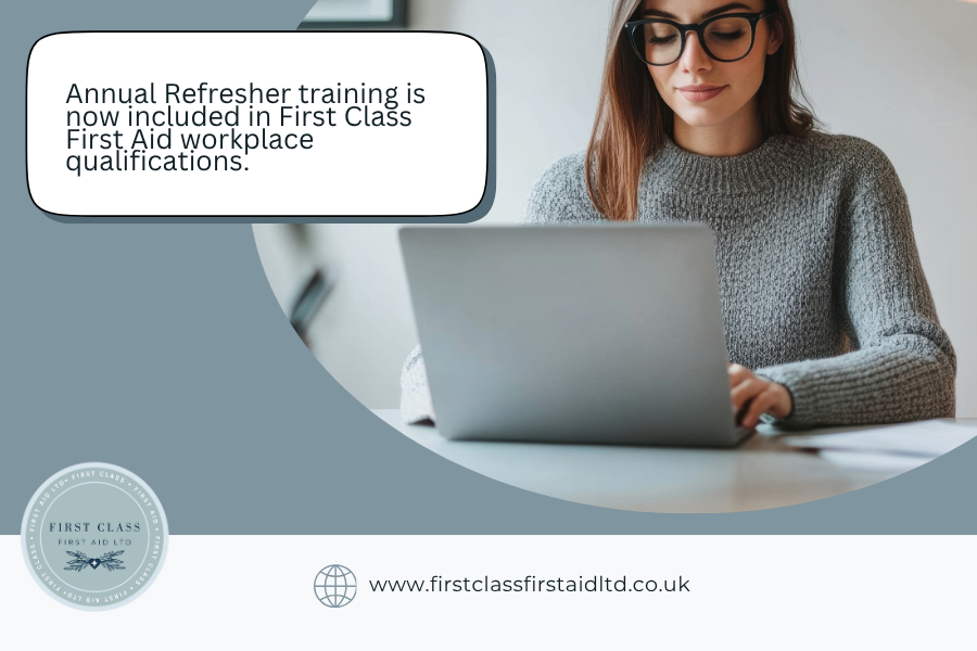 A woman is working at an open laptop while smiling