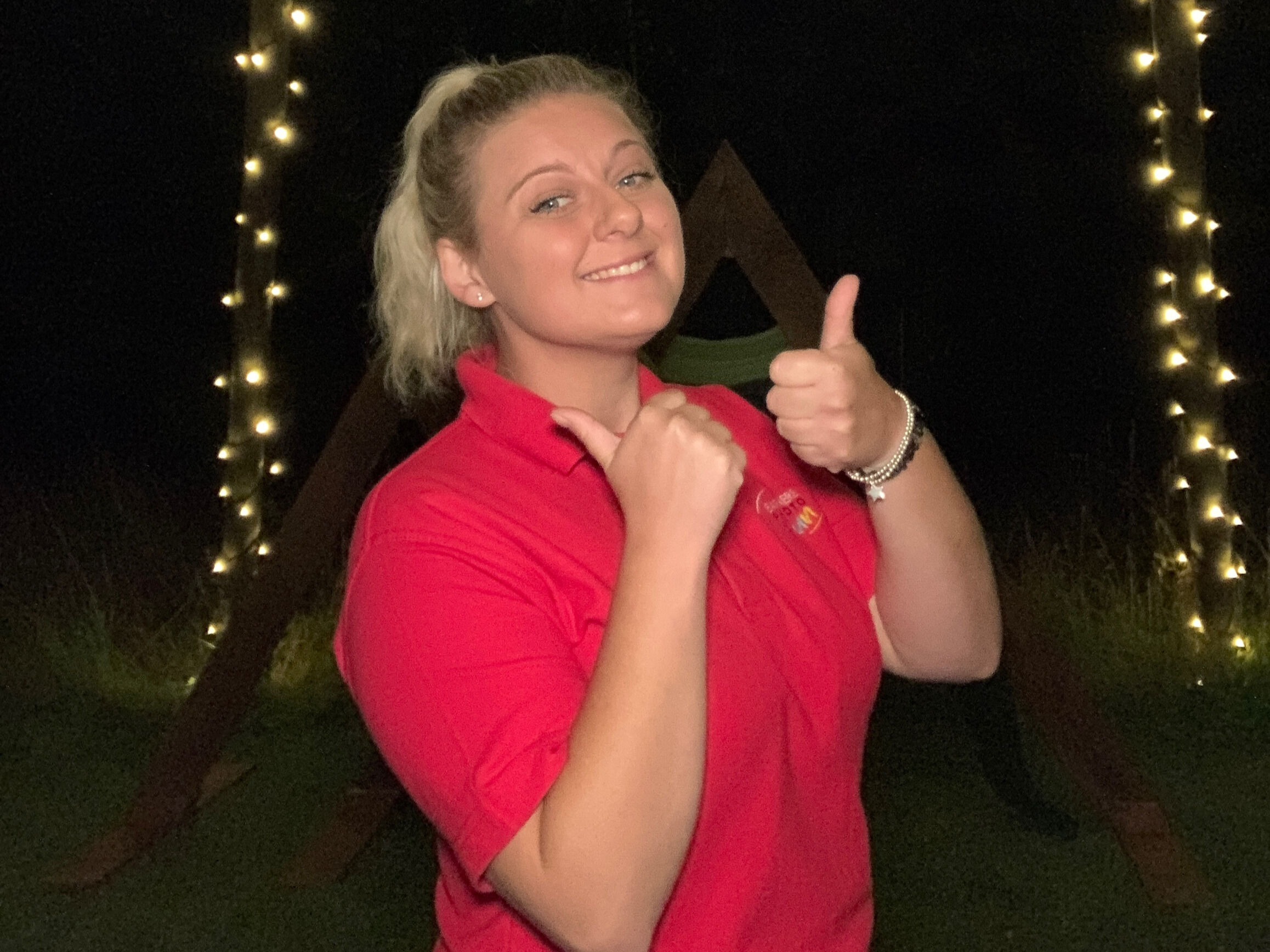 Natsha at an event with thumbs up and a smile